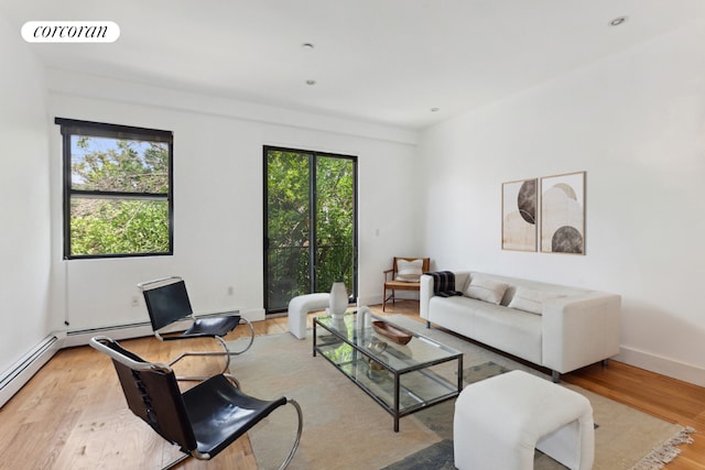 living room featuring baseboards, light wood-style flooring, visible vents, and a healthy amount of sunlight