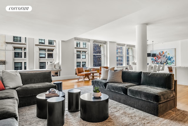 living area with visible vents, light wood-style flooring, and baseboards