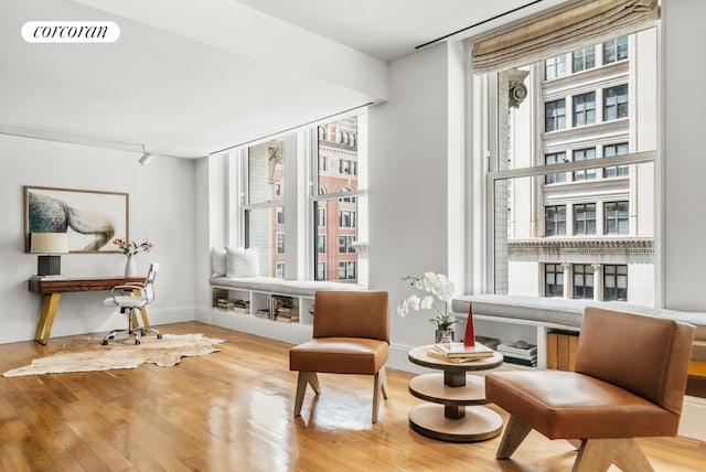 living area featuring visible vents, wood finished floors, a wealth of natural light, and baseboards