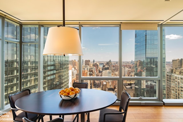 dining area featuring hardwood / wood-style flooring and a wall of windows