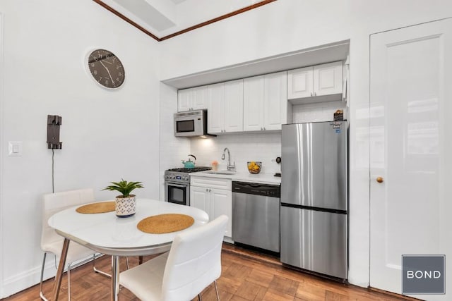 kitchen featuring light parquet flooring, white cabinets, sink, and stainless steel appliances