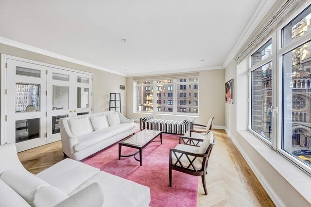 living room featuring crown molding and light parquet floors