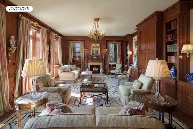 living area featuring a lit fireplace and a notable chandelier