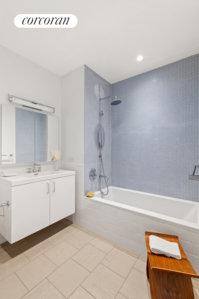 full bathroom featuring tile patterned floors, tiled shower / bath, and vanity