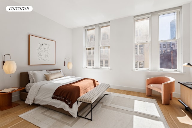 bedroom with visible vents, baseboards, and wood finished floors