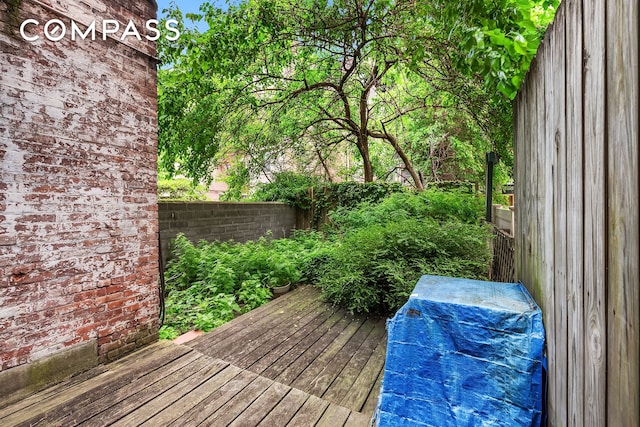 wooden deck with a fenced backyard