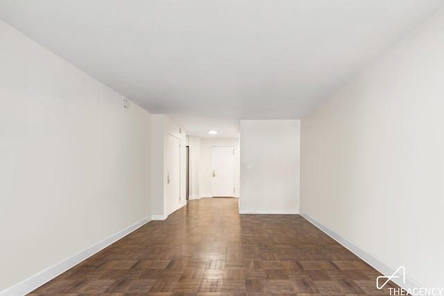 unfurnished room with baseboards