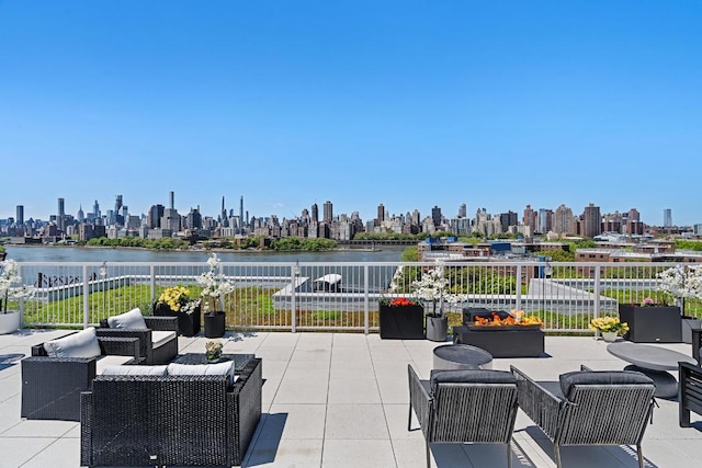 view of patio / terrace featuring a water view and an outdoor living space with a fire pit