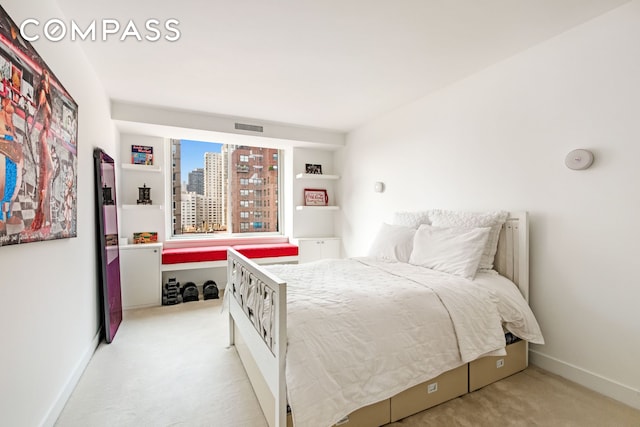 bedroom featuring a view of city, light carpet, visible vents, and baseboards