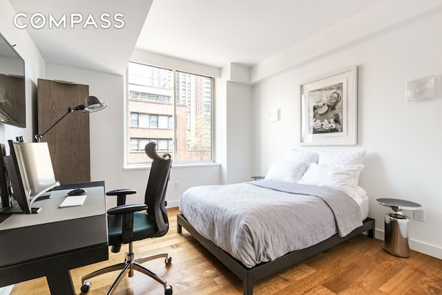 bedroom with wood finished floors and baseboards