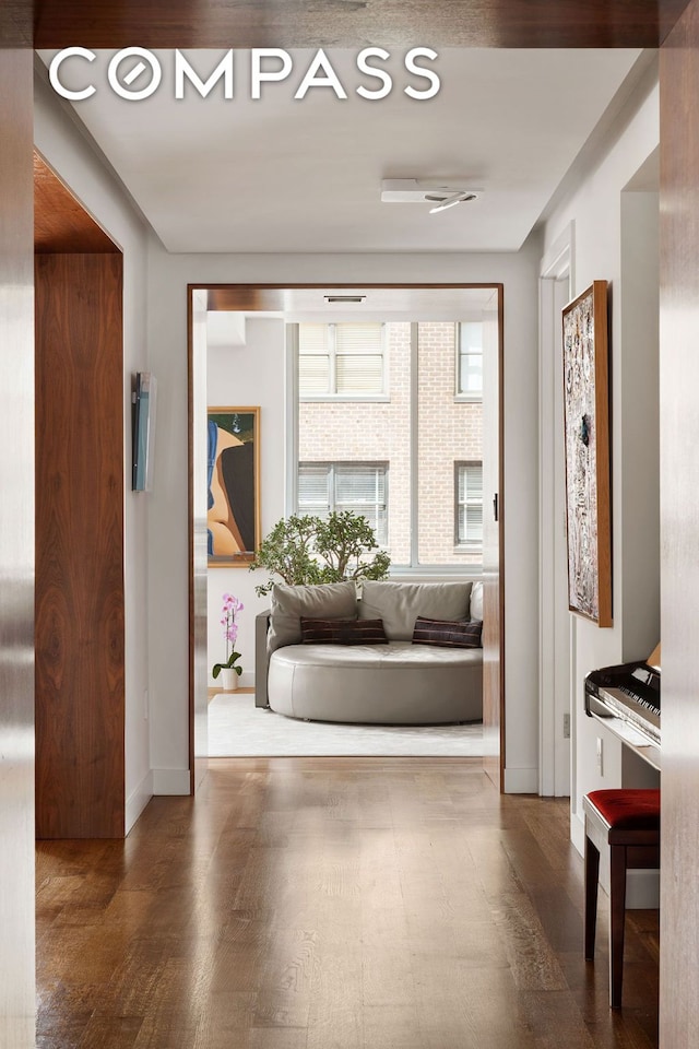 hall featuring baseboards and wood finished floors