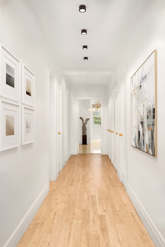 hallway with baseboards and light wood-style floors