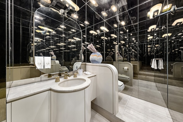 bathroom featuring vanity, tile patterned flooring, toilet, and a bidet