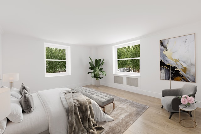 bedroom with multiple windows and light hardwood / wood-style flooring