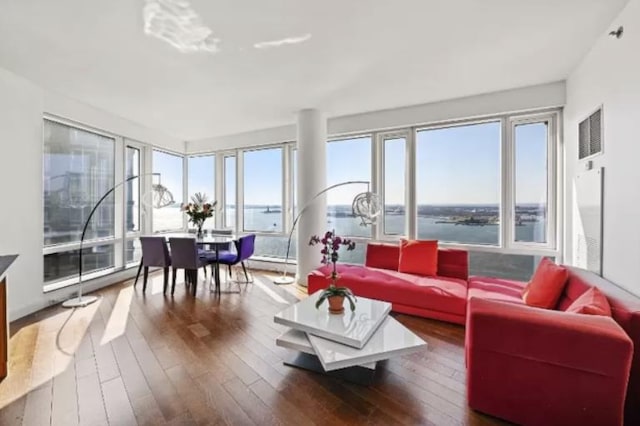 sunroom with a baseboard heating unit, a water view, and visible vents