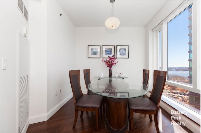 dining area with baseboards, visible vents, and wood finished floors