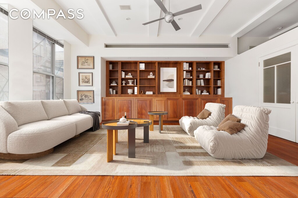 living room with ceiling fan, built in features, beamed ceiling, and hardwood / wood-style floors