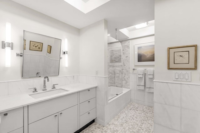 full bath with a skylight, vanity, and tub / shower combination