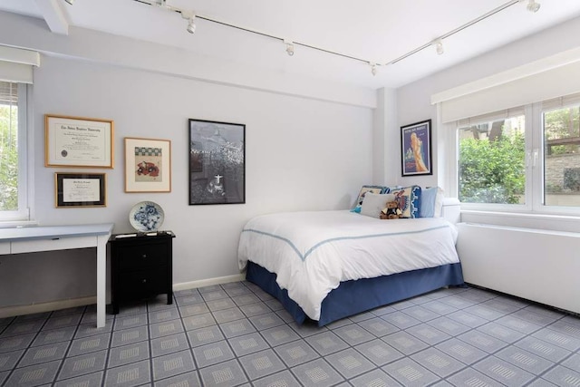 bedroom featuring track lighting, tile patterned floors, and multiple windows