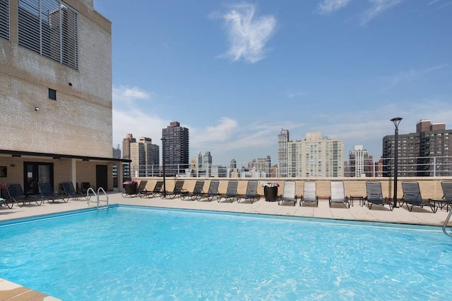 view of swimming pool with a view of city and a patio