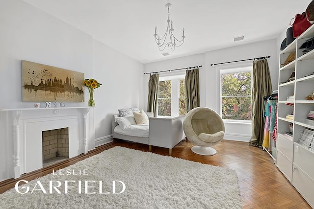 sitting room featuring a notable chandelier and parquet flooring