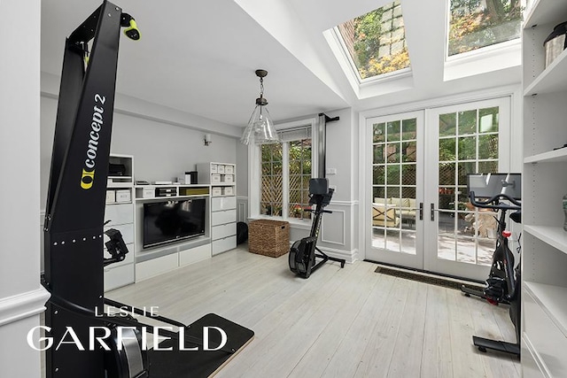 workout room featuring lofted ceiling, wood-type flooring, and french doors