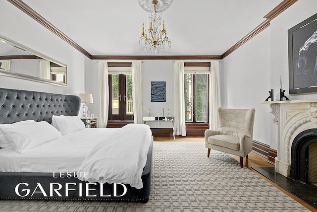 bedroom with ornamental molding, an inviting chandelier, a high end fireplace, and french doors