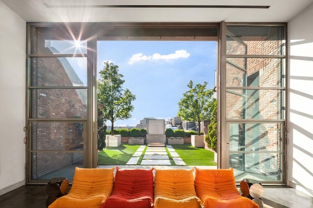 doorway with a healthy amount of sunlight, concrete floors, and a wall of windows