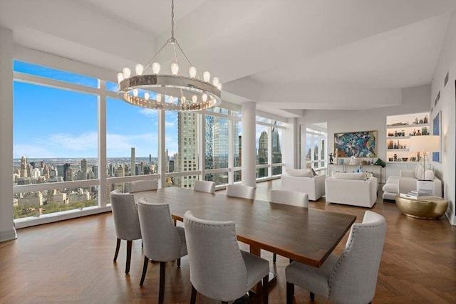 dining room featuring parquet floors, a healthy amount of sunlight, expansive windows, and a notable chandelier