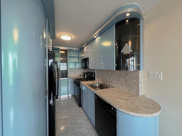 kitchen with blue cabinetry, sink, black appliances, light tile patterned floors, and backsplash