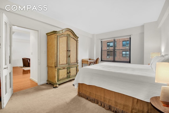 bedroom featuring baseboards and light colored carpet