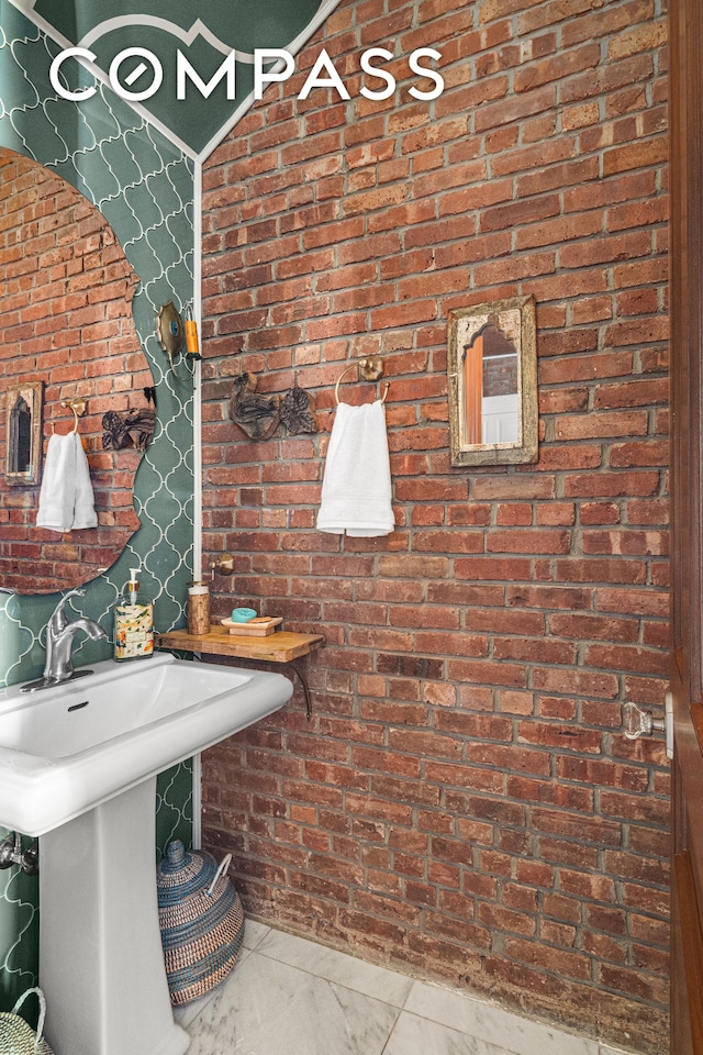 bathroom featuring marble finish floor and a sink