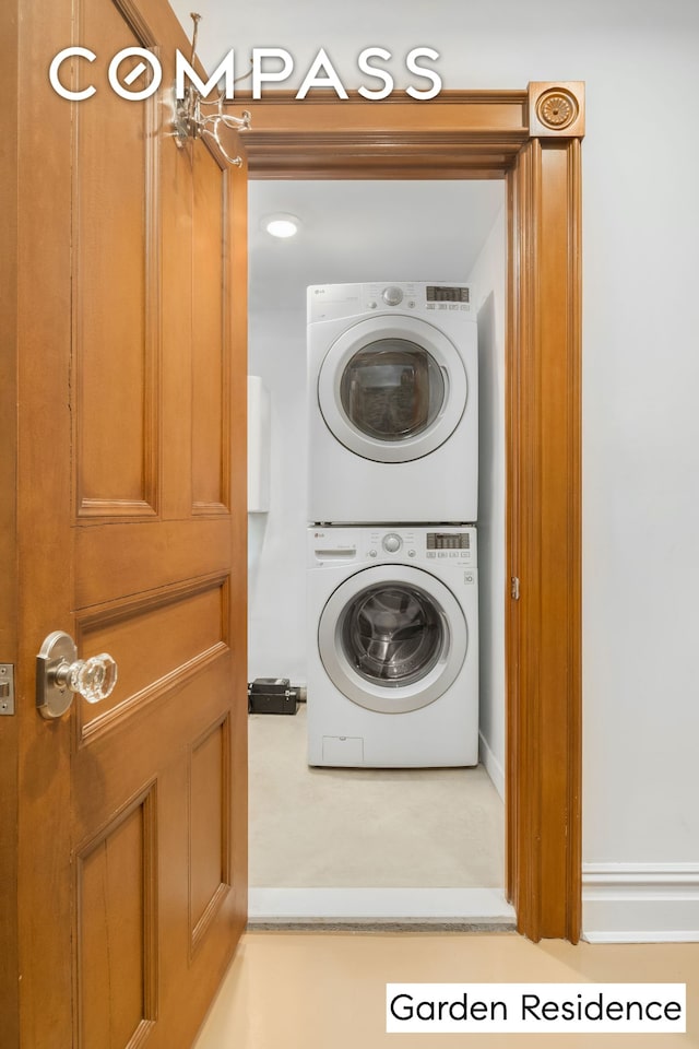 clothes washing area featuring stacked washer and clothes dryer and laundry area