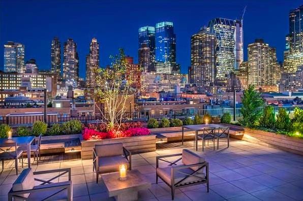 view of community with a patio area and a view of city lights