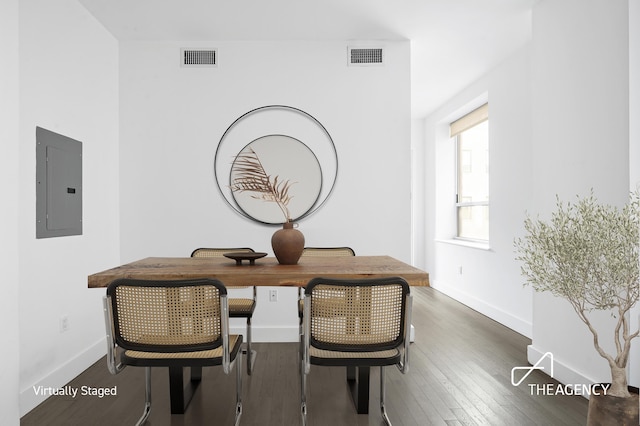 dining room featuring baseboards, electric panel, visible vents, and hardwood / wood-style floors