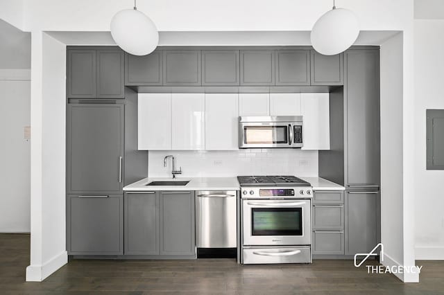 kitchen with gray cabinets, stainless steel appliances, a sink, and light countertops