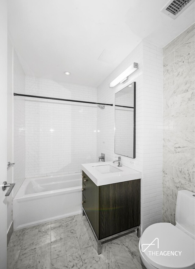 bathroom featuring visible vents, tile walls, toilet, and vanity