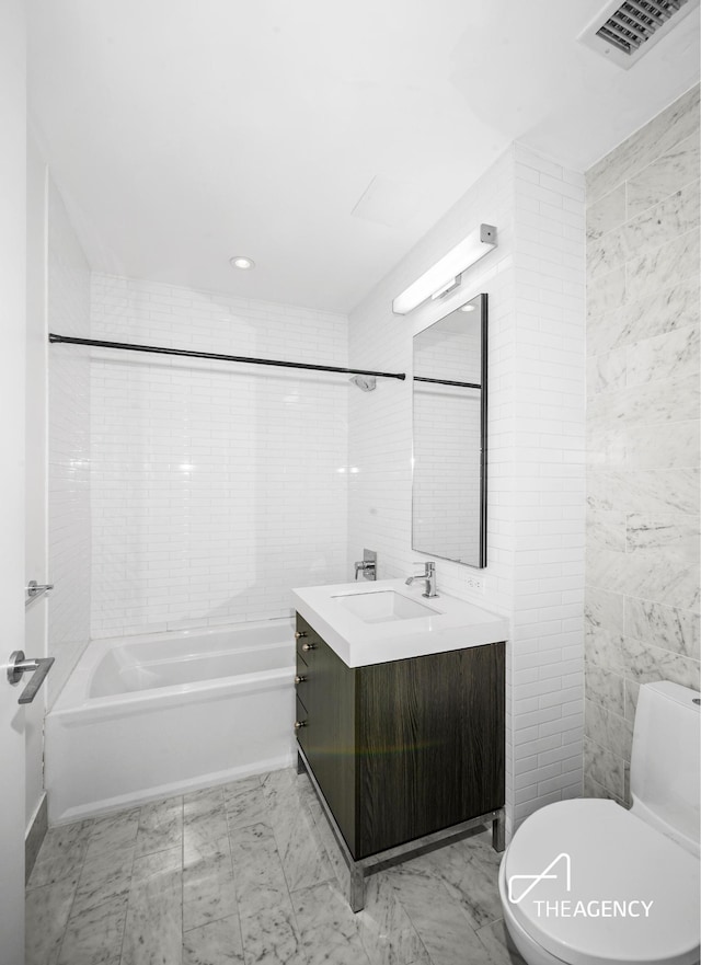 full bath with marble finish floor, tile walls, visible vents, toilet, and vanity