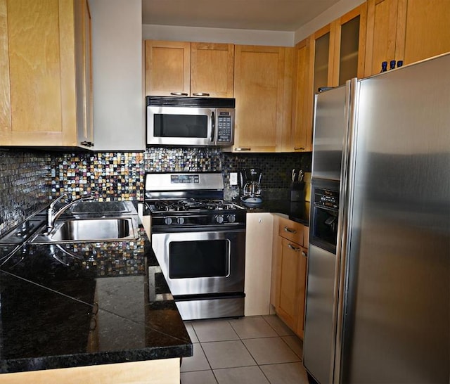 kitchen featuring tasteful backsplash, appliances with stainless steel finishes, sink, and light tile patterned floors