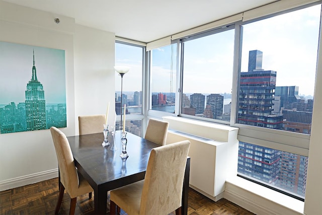 dining room with a city view, plenty of natural light, and baseboards