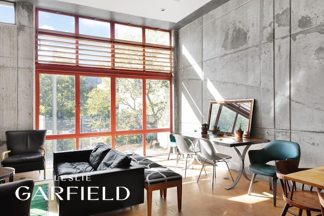 56 E 1st St, New York City, NY 10003 - living room featuring floor to ceiling windows, concrete floors, and a towering ceiling