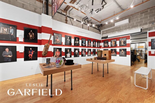 56 E 1st St, New York City, NY 10003 - interior space featuring wood finished floors, a towering ceiling, and rail lighting