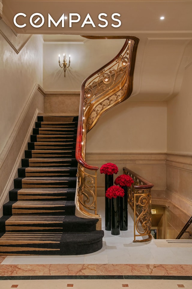 stairway with a wainscoted wall