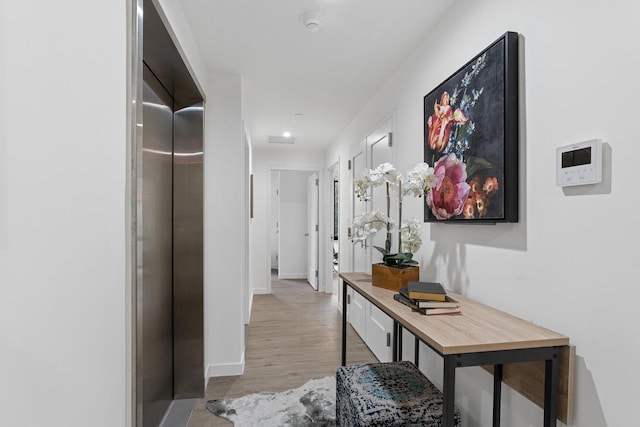 hall with wood finished floors and baseboards