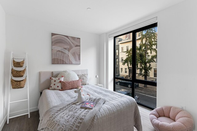 bedroom with access to outside, baseboards, and wood finished floors