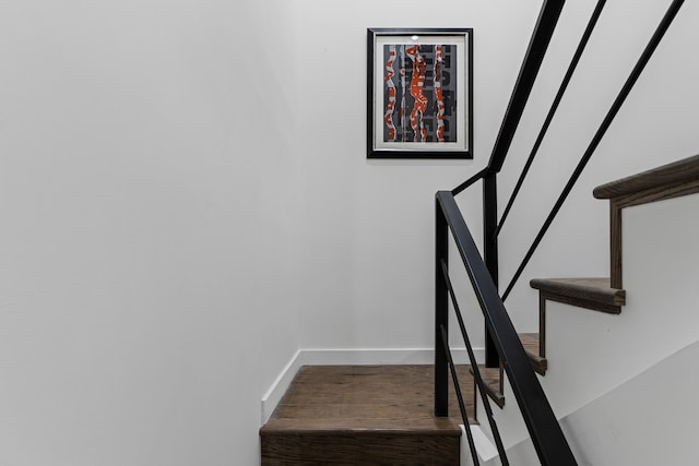 stairway featuring baseboards and wood finished floors