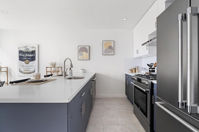 kitchen with a peninsula, wall chimney exhaust hood, light countertops, and stainless steel appliances