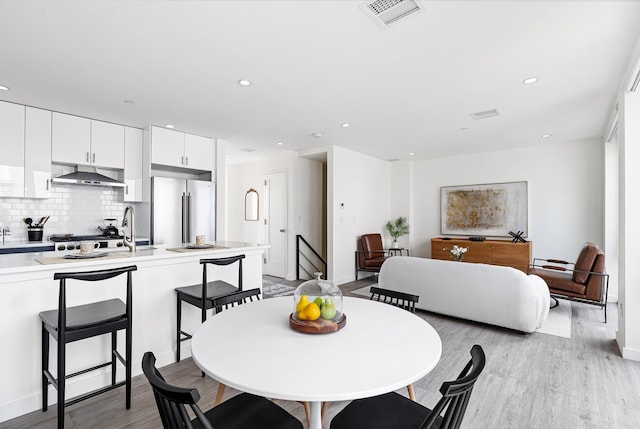 dining area with recessed lighting, visible vents, and light wood-style flooring