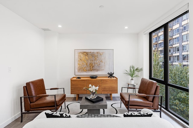 living area featuring visible vents, recessed lighting, wood finished floors, and baseboards