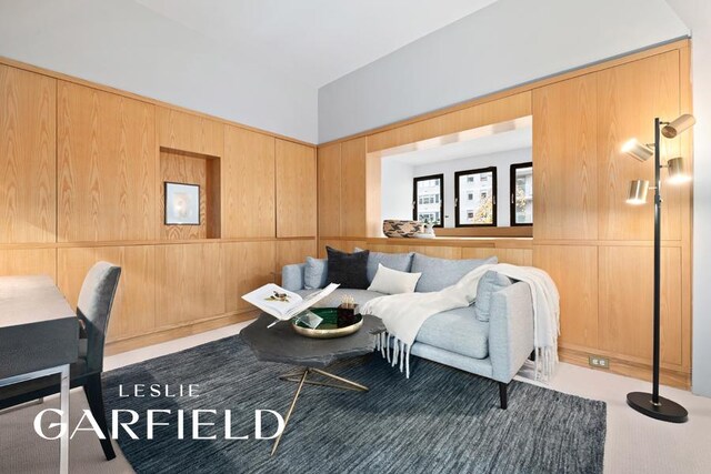 living room with built in shelves, floor to ceiling windows, and light hardwood / wood-style flooring